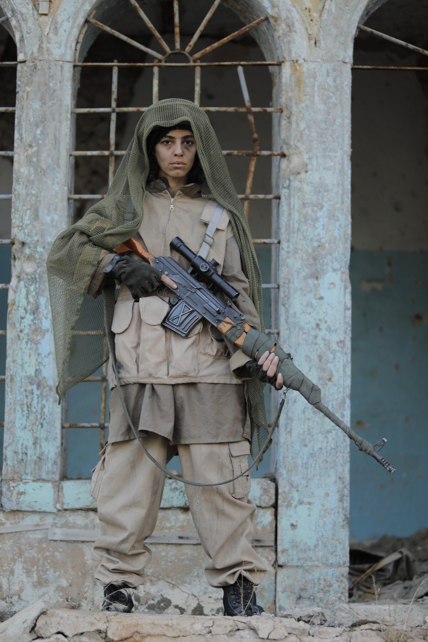 Gheed in a character portrait wearing a hood and holding a rifle